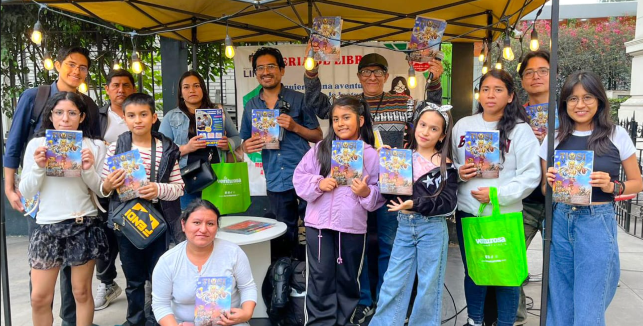 Foto del grupo de lanzamiento de TIQSI Cómics, con personas sosteniendo la revista bajo un toldo
